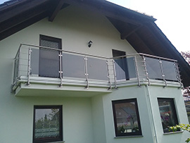 Geländer für Balkon mit Edelstahl-Stäben und grauen ESG-Glas